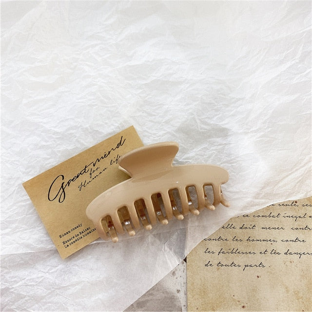 "A trendy jumbo hair claw clip with a shiny beige